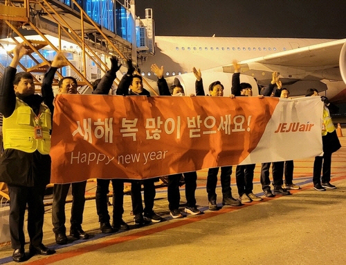 김이배(왼쪽 여섯번째) 제주항공 대표이사와 임직원들이 1일 오전 인천국제공항에서 새해 첫 여객편 탑승객들에게 인사하고 있다. [제주항공 제공]